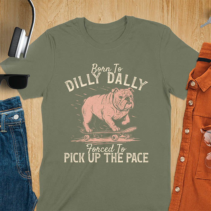 Grumpy bulldog on skateboard illustration with Born To Dilly Dally text and Forced To Pick Up The Pace slogan on military green tee