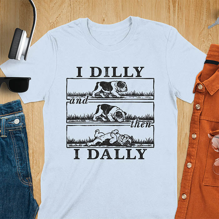 Light blue t-shirt with vintage comic strip graphic of a bulldog walking, rolling, then lying belly-up with text I Dilly and then I Dally