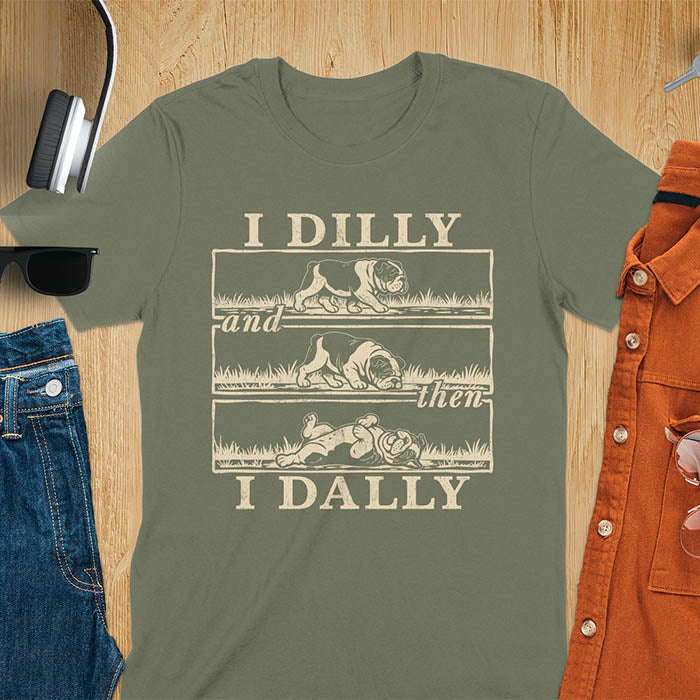Military green t-shirt with vintage comic strip graphic of a bulldog walking, rolling, then lying belly-up with text I Dilly and then I Dally