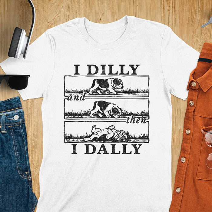White t-shirt with vintage comic strip graphic of a bulldog walking, rolling, then lying belly-up with text I Dilly and then I Dally