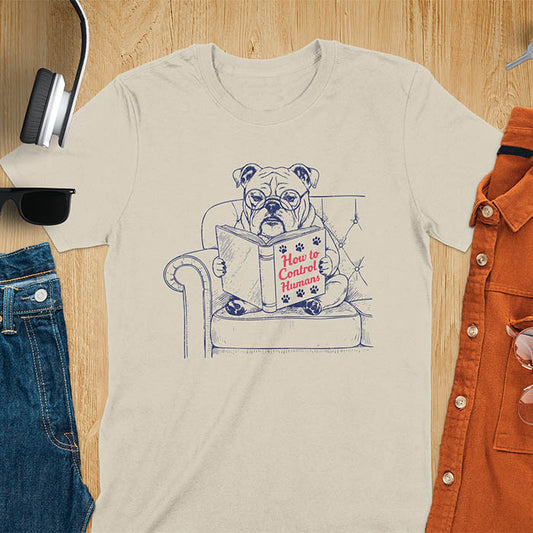 Sand color t-shirt with vintage bulldog illustration reading 'How to Control Human' book on couch - retro graphic design with humor