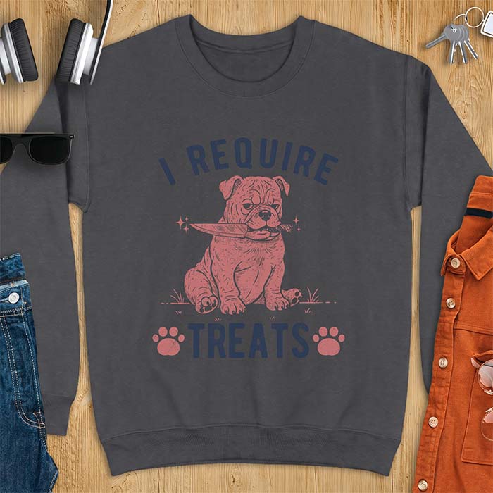 Dark Heather sweatshirt with a graphic of a deadpan English Bulldog puppy sitting in grass holding a knife in its mouth, with the text I Require Treats and two paw prints