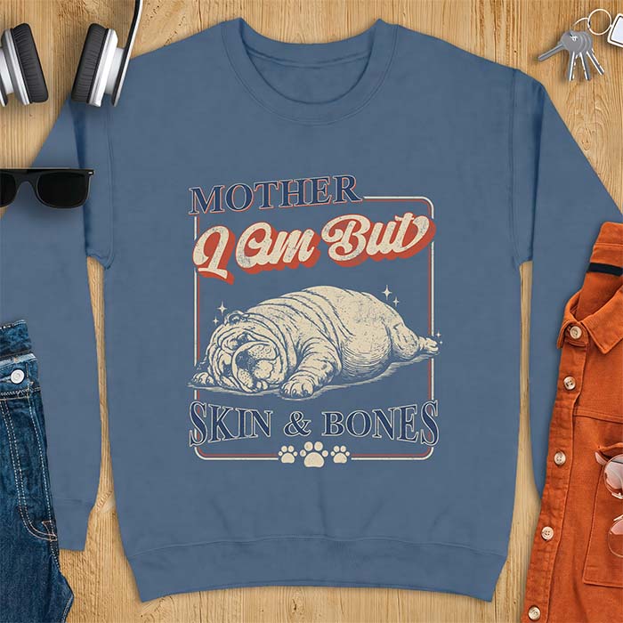 Indigo Blue sweatshirt with a graphic of an English Bulldog sprawled flat and exhausted, small sparkles floating near its head and the text Mother I Am But Skin & Bones