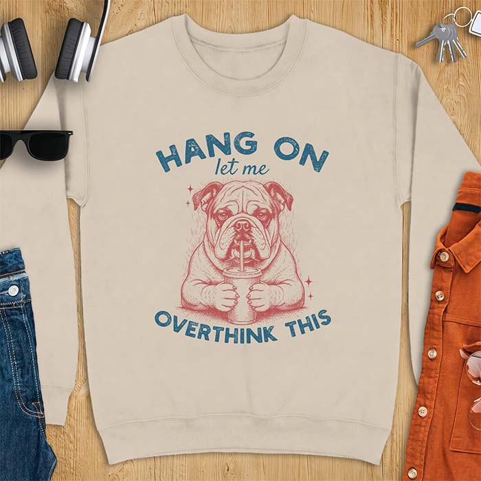 Sand sweatshirt with a graphic of an English Bulldog holding an iced coffee with a straw, with the text Hang On Let Me Overthink This