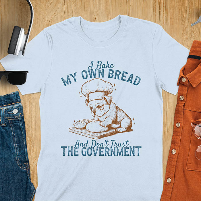 Light blue tee with "I Bake My Own Bread Don't Trust Government" text and vintage bulldog puppy in chef hat kneading bread graphic
