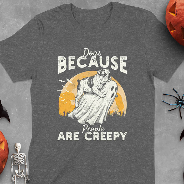 Heather grey Halloween t-shirt featuring bulldog riding piggyback on ghost with moon background and bats, text reads 'Dogs Because People Are Creepy'