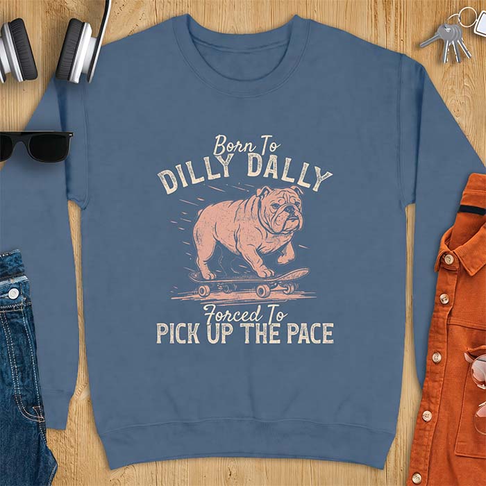 Indigo Blue sweatshirt with a vintage graphic of an English Bulldog riding a skateboard with speed lines behind it and the text Born To Dilly Dally Forced To Pick Up The Pace