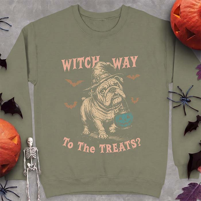 Military Green sweatshirt with a Halloween graphic of an English Bulldog wearing a patched witch hat carrying a glowing jack-o'-lantern lantern in its mouth with bats flying nearby and the text Witch Way To The Treats?