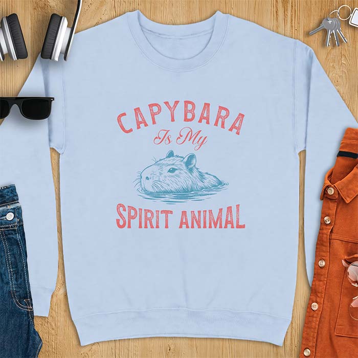Light Blue sweatshirt with a graphic of a capybara relaxing in water and the text Capybara Is My Spirit Animal