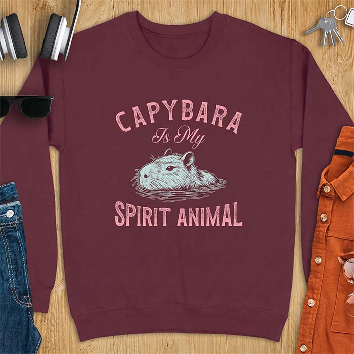 Maroon sweatshirt with a graphic of a capybara relaxing in water and the text Capybara Is My Spirit Animal