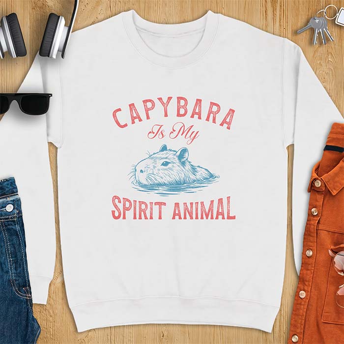 White sweatshirt with a graphic of a capybara relaxing in water and the text Capybara Is My Spirit Animal