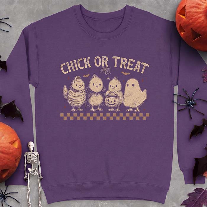 Purple sweatshirt with a Halloween graphic of four baby chicks dressed as a mummy, a vampire, a pumpkin bucket trick-or-treater and a ghost, with the text Chick Or Treat