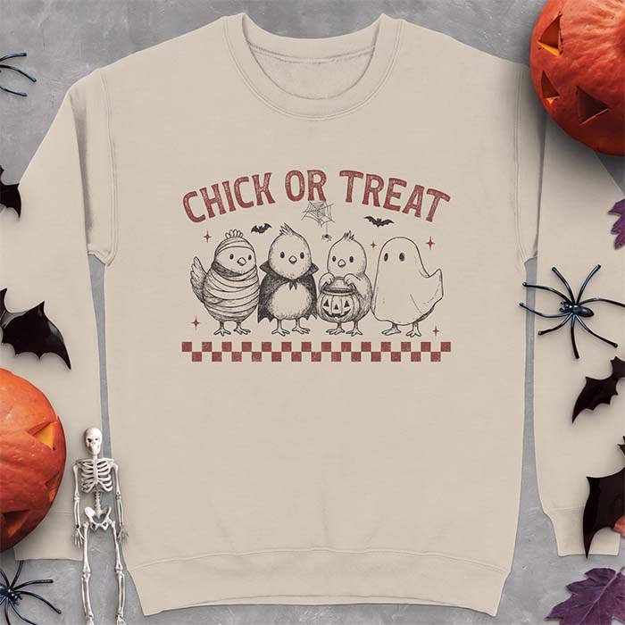 Sand sweatshirt with a Halloween graphic of four baby chicks dressed as a mummy, a vampire, a pumpkin bucket trick-or-treater and a ghost, with the text Chick Or Treat