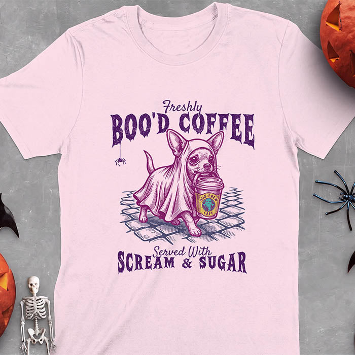 Light Pink t-shirt with a Halloween graphic of a Chihuahua wearing a ghost costume and holding a coffee cup labeled Boo-Brew Cafe on a cobblestone street with a spider dangling above, plus the text Freshly Boo'd Coffee, Served With Scream and Sugar