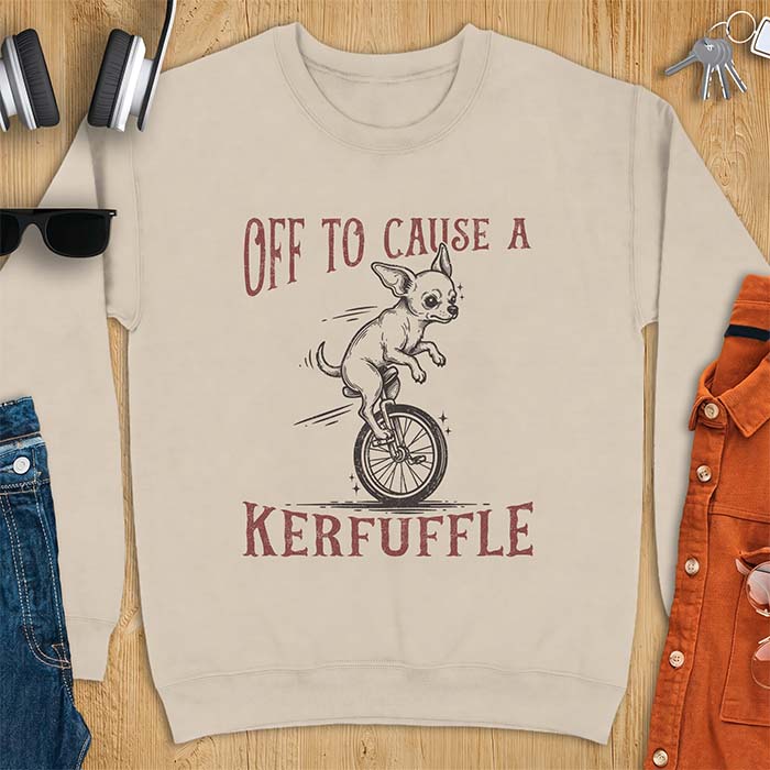 Sand sweatshirt with a graphic of a chihuahua riding a unicycle with motion lines behind it and the text Off To Cause A Kerfuffle