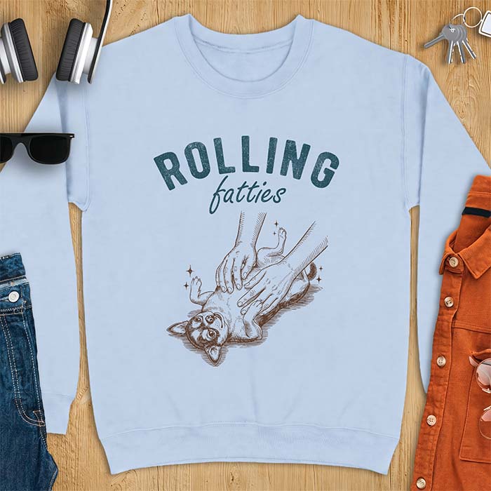 Light Blue sweatshirt with a graphic of a chubby Chihuahua rolled onto its back getting a two-handed belly rub with tiny sparkles around it, above the text Rolling Fatties