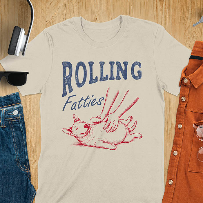 Sand color t-shirt with chubby Bull Terrier belly rub graphic featuring 'Rolling Fatties' text, funny dog meme design