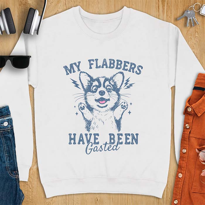 White sweatshirt with a corgi illustration, paws raised in shock, mouth open in a gasp, lightning bolts beside its ears, and the text My Flabbers Have Been Gasted