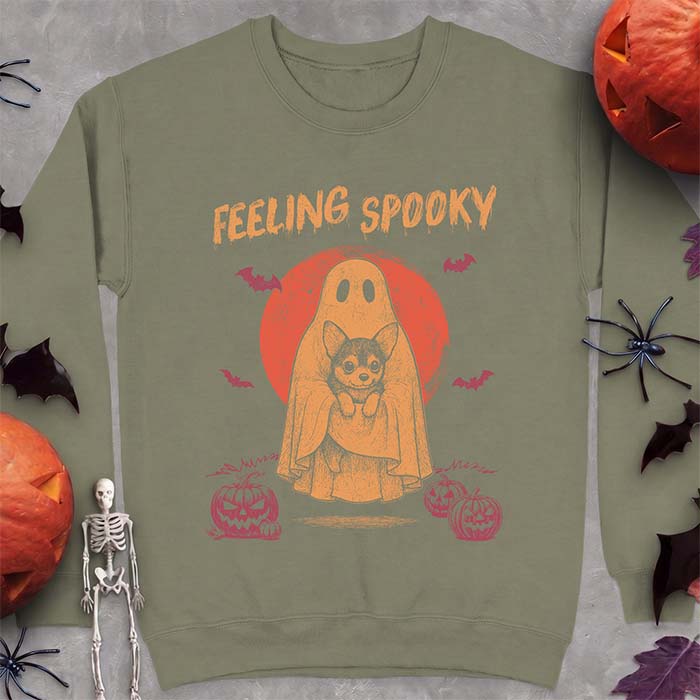Military Green sweatshirt with a Halloween graphic of a ghost holding a wide-eyed Corgi puppy in front of a red moon with bats and jack-o-lanterns, with the text Feeling Spooky