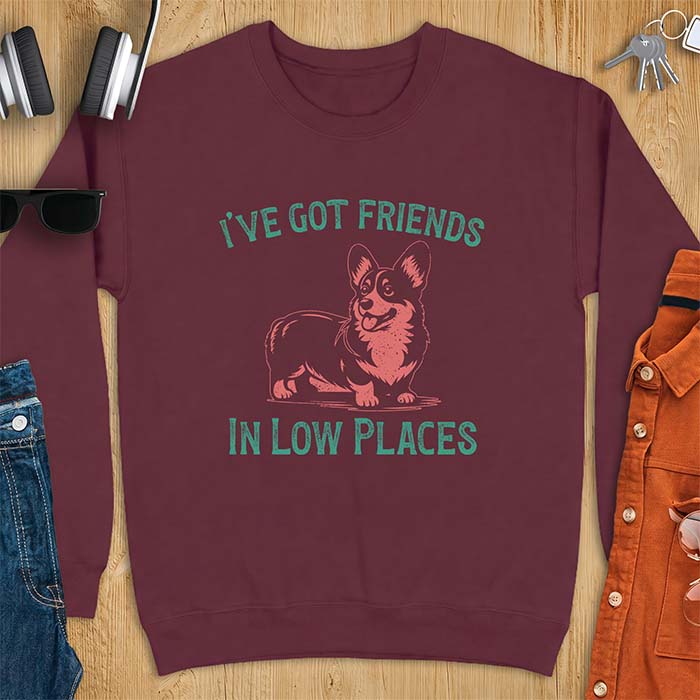 Maroon sweatshirt with a vintage Corgi illustration standing and facing forward, with distressed teal text arched above reading "I'VE GOT FRIENDS" and below reading "IN LOW PLACES.