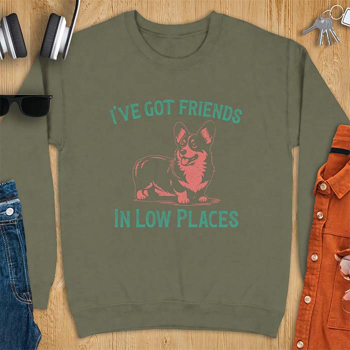 Military green sweatshirt with a vintage Corgi illustration standing and facing forward, with distressed teal text arched above reading "I'VE GOT FRIENDS" and below reading "IN LOW PLACES.