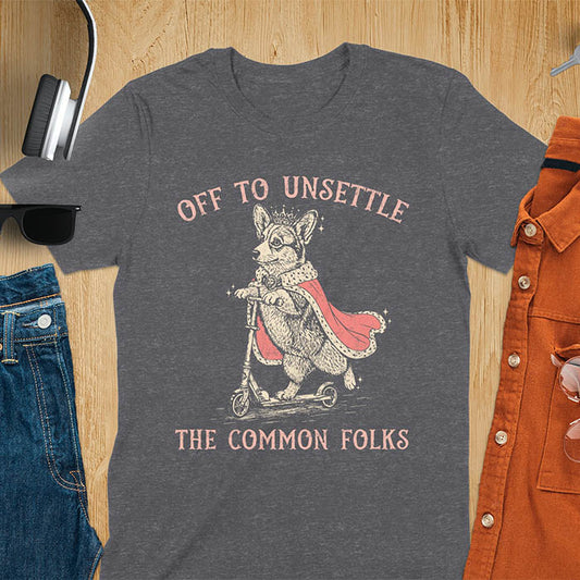 Off To Unsettle The Common Folks text with king corgi wearing crown and red cape on skateboard scooter vintage meme graphic on dark heather t-shirt