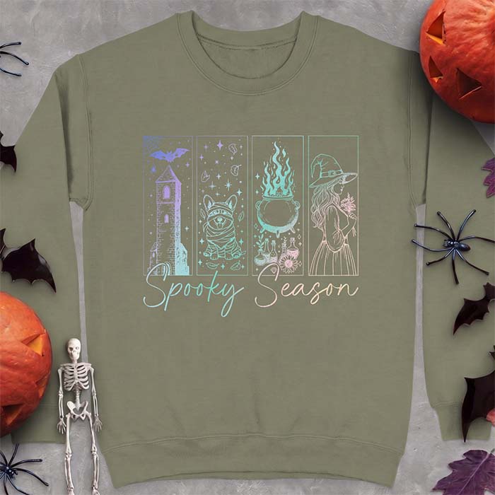 Military Green sweatshirt with a four-panel Halloween graphic of a haunted tower, a bandage-wrapped Corgi mummy, a bubbling cauldron with potion bottles and a witch holding flowers, with the text Spooky Season