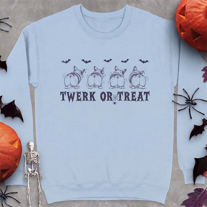 Light Blue sweatshirt with a Halloween graphic of four Corgis viewed from behind shaking their rumps, bats flying above and a spider on a web, with the text Twerk Or Treat