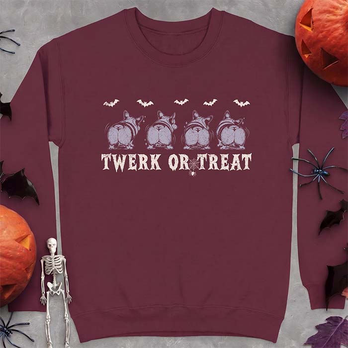 Maroon sweatshirt with a Halloween graphic of four Corgis viewed from behind shaking their rumps, bats flying above and a spider on a web, with the text Twerk Or Treat