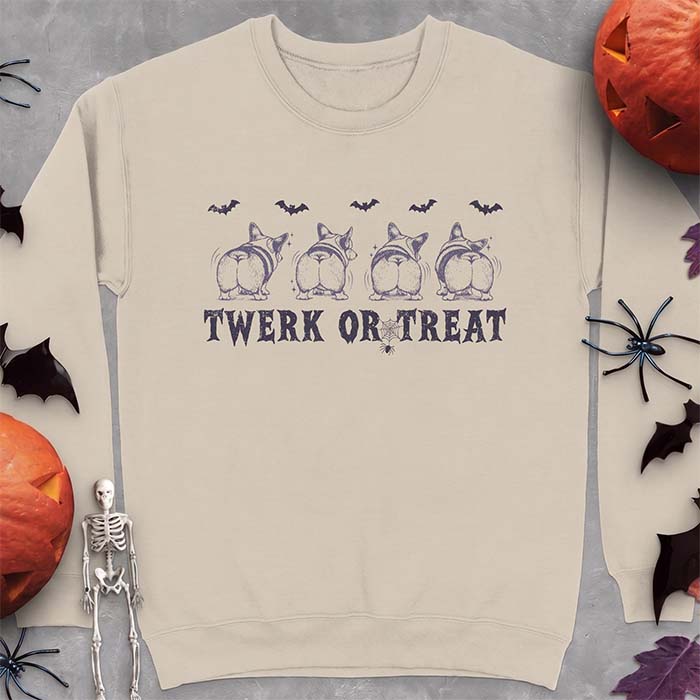 Sand sweatshirt with a Halloween graphic of four Corgis viewed from behind shaking their rumps, bats flying above and a spider on a web, with the text Twerk Or Treat