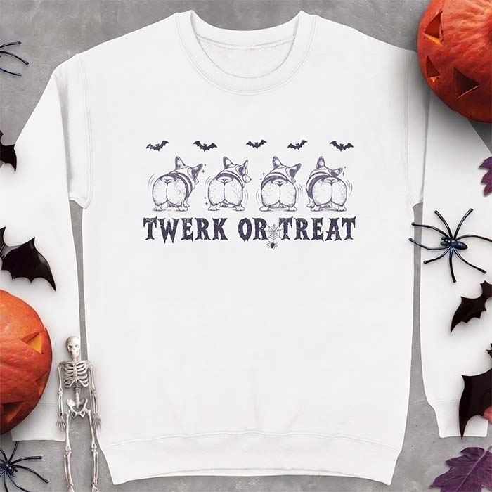 White sweatshirt with a Halloween graphic of four Corgis viewed from behind shaking their rumps, bats flying above and a spider on a web, with the text Twerk Or Treat