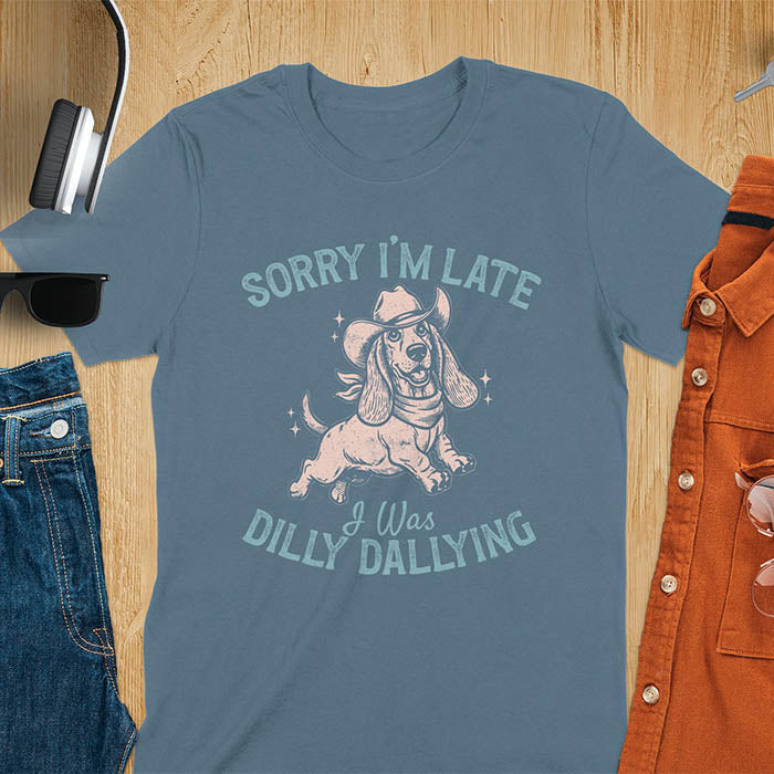 Indigo Blue t-shirt featuring a galloping basset hound wearing a cowboy hat with long floppy ears flowing, text reads Sorry I'm Late I Was Dilly Dallying