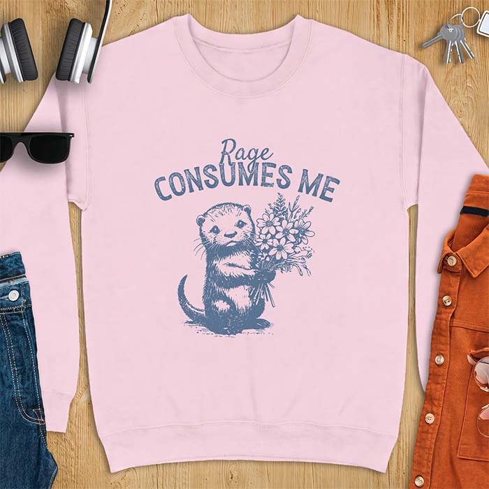 Light Pink sweatshirt with a graphic of an otter standing upright holding a bouquet of wildflowers and the text Rage Consumes Me