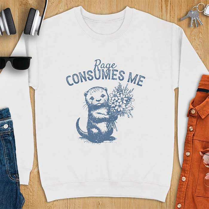White sweatshirt with a graphic of an otter standing upright holding a bouquet of wildflowers and the text Rage Consumes Me