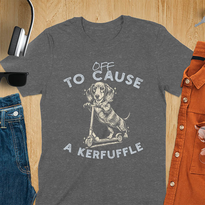 Dachshund on kick scooter illustrated graphic with Off To Cause A Kerfuffle text on dark heather t-shirt
