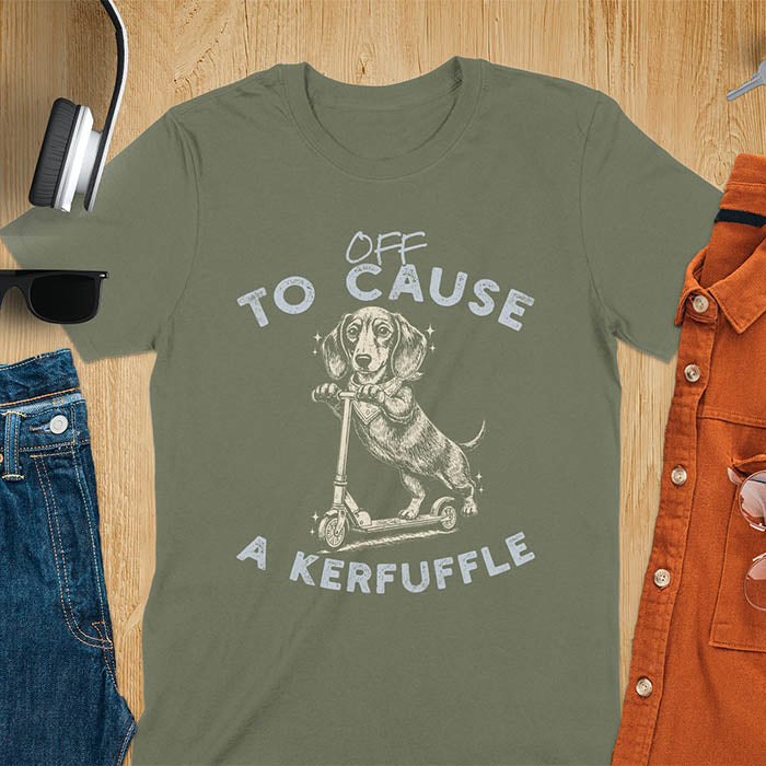 Dachshund on kick scooter illustrated graphic with Off To Cause A Kerfuffle text on military green t-shirt
