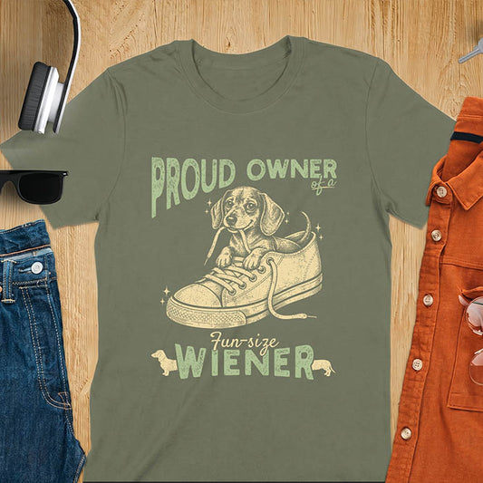 Military Green unisex t-shirt with a vintage dachshund graphic of a wiener dog pup sitting inside a classic sneaker, with retro bold lettering reading Proud Owner of a Fun-Size Wiener
