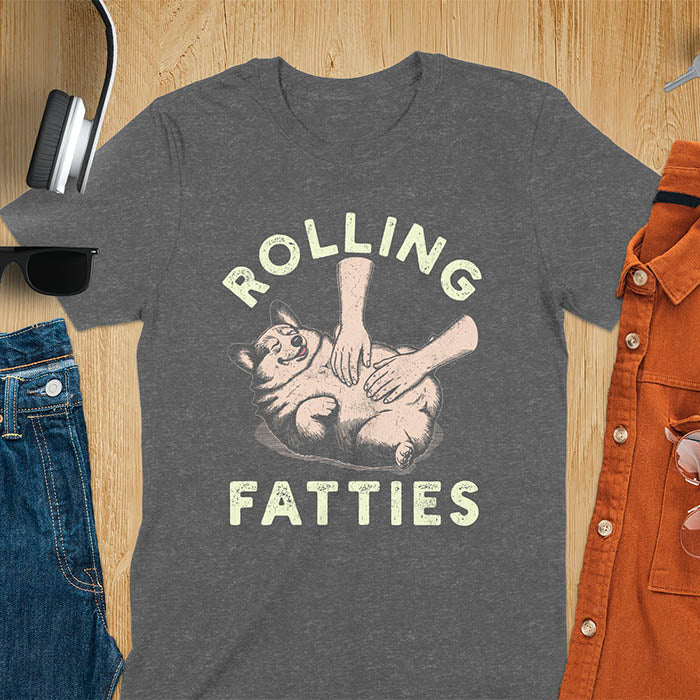 Chubby corgi illustration enjoying tummy rubs with Rolling Fatties text in textured lettering on dark heather tee