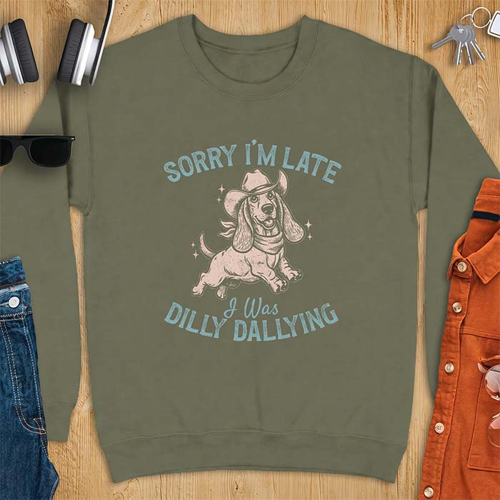 Military Green sweatshirt with a graphic of a basset hound wearing a cowboy hat and bandana trotting with sparkles around it and the text Sorry I'm Late I Was Dilly Dallying