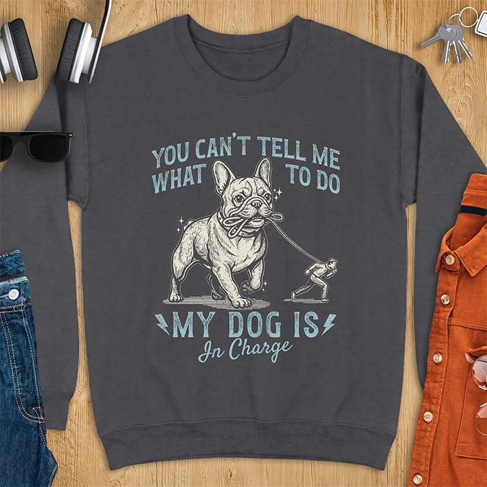 Dark Heather sweatshirt with a graphic of a French Bulldog walking a smaller man by the leash and the text “You Can’t Tell Me What To Do. My Dog Is In Charge.”