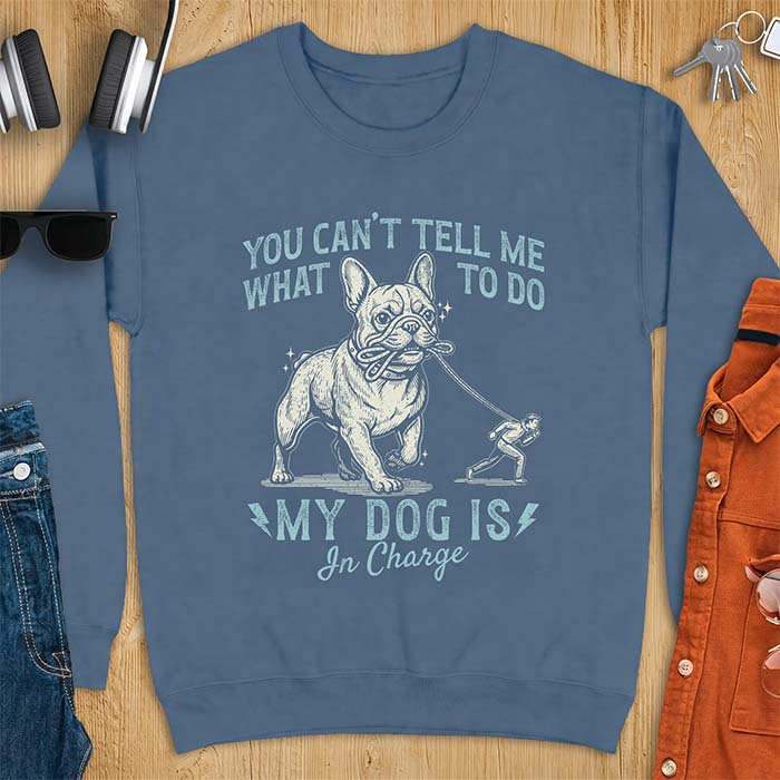 Indigo Blue sweatshirt with a graphic of a French Bulldog walking a smaller man by the leash and the text “You Can’t Tell Me What To Do. My Dog Is In Charge.”