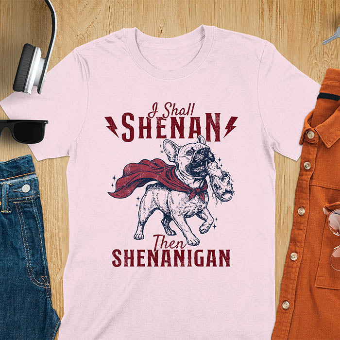 Light Pink tee with vintage Frenchie in red cape biting on a chewed slipper, text reads I Shall Shenan Then Shenanigan