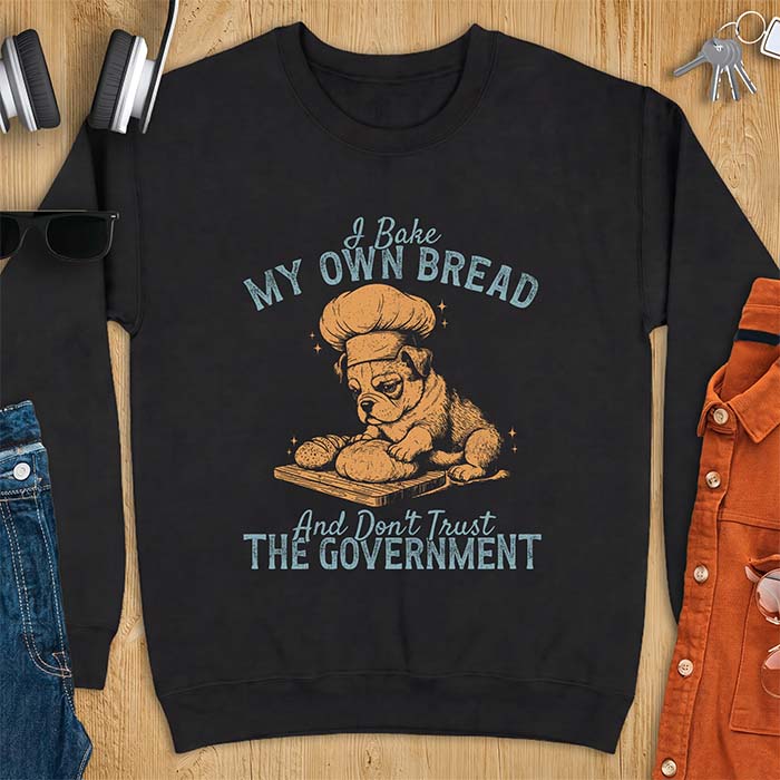 Black sweatshirt with a graphic of a bulldog wearing a chef hat kneading bread dough on a cutting board and the text I Bake My Own Bread And Don't Trust The Government