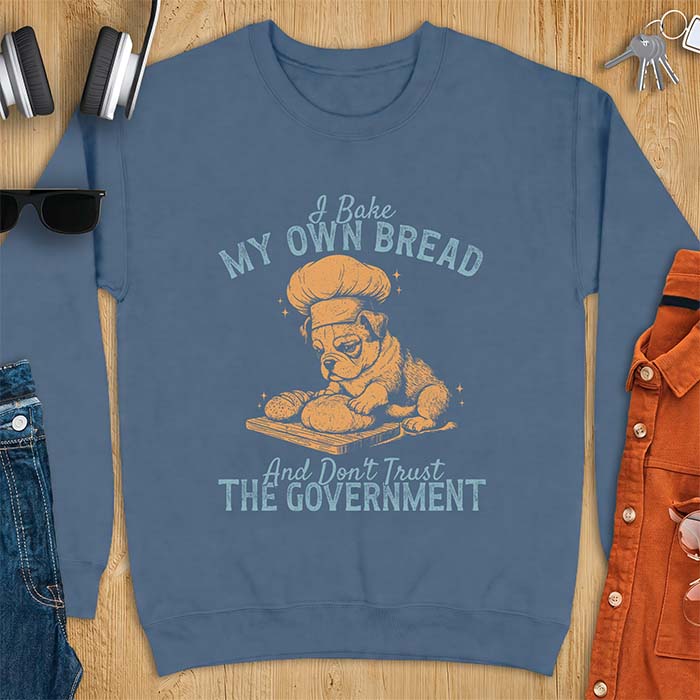 Indigo Blue sweatshirt with a graphic of a bulldog wearing a chef hat kneading bread dough on a cutting board and the text I Bake My Own Bread And Don't Trust The Government