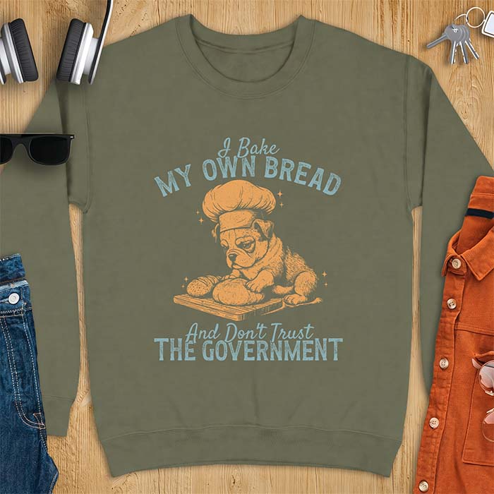 Military Green sweatshirt with a graphic of a bulldog wearing a chef hat kneading bread dough on a cutting board and the text I Bake My Own Bread And Don't Trust The Government
