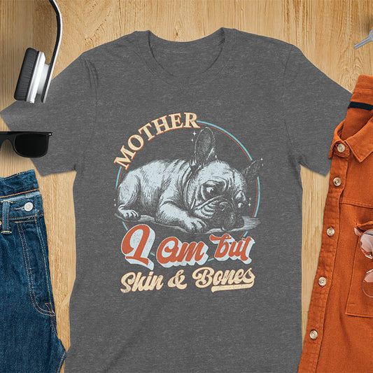 French Bulldog lying down with a sulky expression, with the text Mother I Am But Skin and Bones in retro typography on a dark heather t-shirt