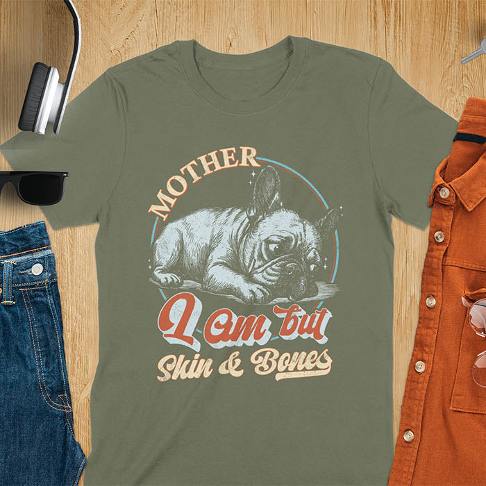 French Bulldog lying down with a sulky expression, with the text Mother I Am But Skin and Bones in retro typography on a military green t-shirt 