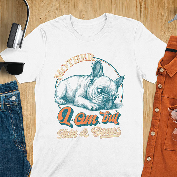 French Bulldog lying down with a sulky expression, with the text Mother I Am But Skin and Bones in retro typography on a white t-shirt