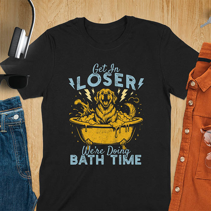 Golden Retriever sitting in a bathtub with soap bubbles and lightning bolts, with the text Get In Loser We're Doing Bath Time on a black t-shirt