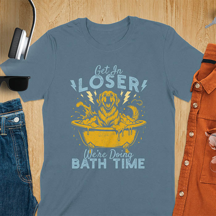 Golden Retriever sitting in a bathtub with soap bubbles and lightning bolts, with the text Get In Loser We're Doing Bath Time on a indigo blue t-shirt
